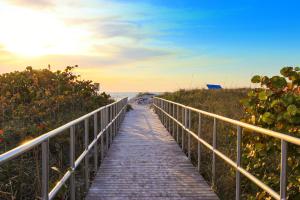 een promenade die bij zonsondergang naar het strand leidt bij Madeira Bay Resort 508 in St Pete Beach
