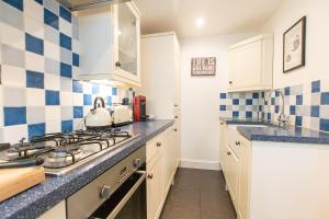 cocina con azulejos azules y blancos en la pared en Stone's Throw, en St Ives
