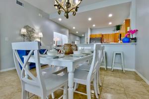 Il comprend une cuisine et une salle à manger avec une table et des chaises blanches. dans l'établissement Harborview Grande 207, à Clearwater Beach