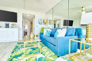 a living room with a blue couch and a table at Belleair Beach Club 112 in Clearwater Beach