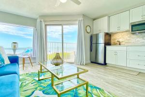 a living room with a glass table and a kitchen at Belleair Beach Club 112 in Clearwater Beach