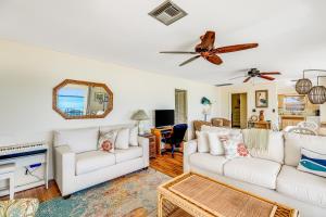 a living room with two white couches and a ceiling fan at Sea and Sky in Marathon