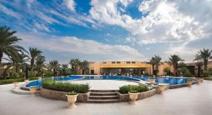ośrodek z basenem i palmami w obiekcie Dorat Najd Resort w Rijadzie