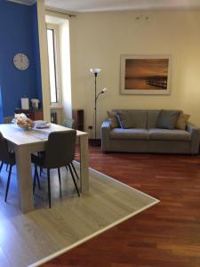 ein Wohnzimmer mit einem Tisch und einem Sofa in der Unterkunft Rosy Apartment Rome in Rom