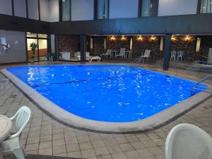 a large blue swimming pool in a building at Ramada by Wyndham Albert Lea in Albert Lea