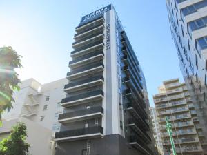 a tall building with a sign on the side of it at HOTEL LiVEMAX PREMIUM Nagoya Marunouchi in Nagoya