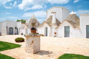 a large white building with a fountain in the yard at Dimore Angiulli - Trulli di Charme in Castellana Grotte