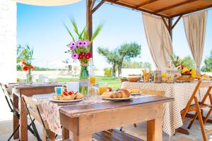 a table with plates of food and flowers on it at Dimore Angiulli - Trulli di Charme in Castellana Grotte