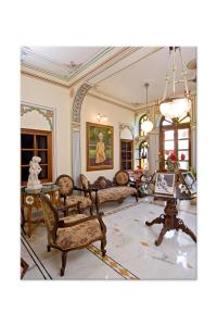 uma sala de estar cheia de mobiliário e um lustre em Madhuban - A Heritage Home em Jaipur