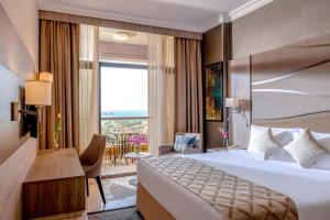 迪拜Two Seasons Hotel & Apartments的带大床和阳台的酒店房间