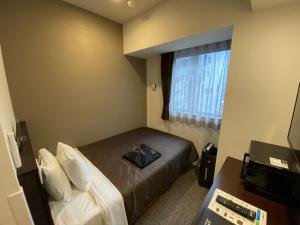 Postel nebo postele na pokoji v ubytování HOTEL LiVEMAX PREMIUM Nagoya Marunouchi
