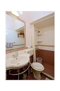 a bathroom with a sink and a toilet and a mirror at Madhuban - A Heritage Home in Jaipur