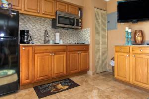 a kitchen with wooden cabinets and a microwave at Belleair Beach Club 315 in Clearwater Beach