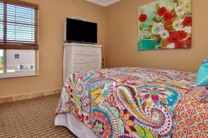a bedroom with a bed and a flat screen tv at Belleair Beach Club 315 in Clearwater Beach