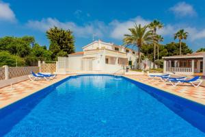 una piscina con sillas y una casa en Apartamento Bon Repos A7, en Cala'n Bosch