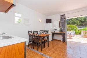 cocina y sala de estar con mesa y sillas en Apartamento Bon Repos A7, en Cala'n Bosch