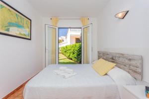 Habitación blanca con cama y ventana en Apartamento Bon Repos A7, en Cala'n Bosch