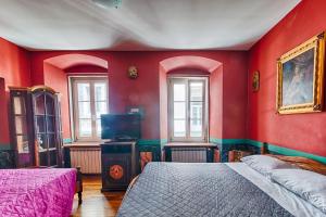 a bedroom with red walls and two beds and windows at Hotel Portacavana in Trieste