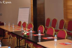 um grupo de mesas e cadeiras numa sala em Hotel La Capitale em Rabat