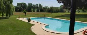 a swimming pool in a yard with a grass field at Beautiful 4 bedroom property near to Monflanquin in Laussou