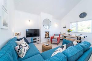 a living room with a blue couch and a table at Shearwater in Carbis Bay