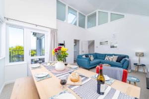 Shearwater في Carbis Bay: غرفة معيشة مع طاولة وأريكة زرقاء