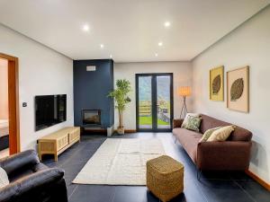 a living room with a couch and a tv at Quinta do Conde by LovelyStay in Fajã do Penedo