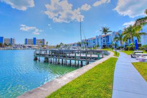a pathway next to a body of water with a pier at Madeira Beach Yacht Club 329H in St. Pete Beach