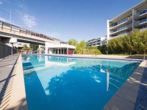 a large swimming pool in front of a building at Oaks Brisbane Mews Suites in Brisbane