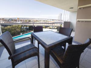 a table and chairs on a balcony with a view at Oaks Brisbane Mews Suites in Brisbane