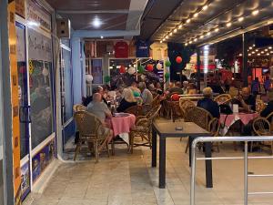 a group of people sitting at tables in a restaurant at Baskent Otel in Didim