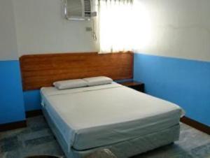 una camera con letto e testiera in legno di GV Hotel - Davao a Davao
