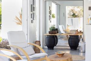 a porch with white chairs and a table at Ladiko Inn Hotel Faliraki -Anthony Quinn Bay in Faliraki