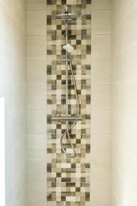 a shower in a bathroom with a tile wall at Hôtel Newport in Villefranche-sur-Saône +43 photos