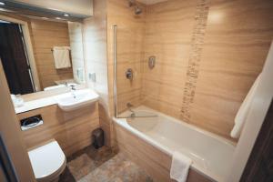 a bathroom with a tub and a toilet and a sink at Blackpool Football Club Stadium Hotel, a member of Radisson Individuals in Blackpool