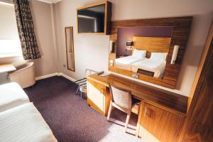 um quarto de hotel com uma cama e uma secretária em Blackpool Football Club Stadium Hotel, a member of Radisson Individuals em Blackpool