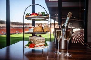 uma mesa com dois pratos de comida e dois copos de vinho em Blackpool Football Club Stadium Hotel, a member of Radisson Individuals em Blackpool