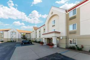 a large building with a car parked in a parking lot at MainStay Suites - Wichita NE in Wichita