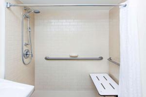 a bathroom with a shower with a toilet and a sink at MainStay Suites - Wichita NE in Wichita