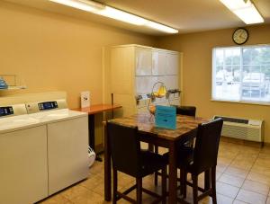 uma cozinha com uma mesa com cadeiras e um balcão em MainStay Suites - Wichita NE em Wichita