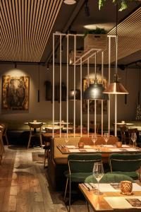 a dining room with tables and chairs and lights at Konvin Hotel by Reykjavik Keflavik Airport in Keflavík