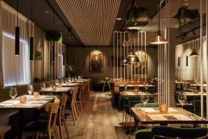 a restaurant with long tables and chairs and lights at Konvin Hotel by Reykjavik Keflavik Airport in Keflavík
