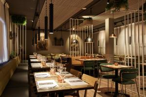 a restaurant with wooden tables and green chairs at Konvin Hotel by Reykjavik Keflavik Airport in Keflavík