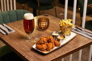 a table with a plate of food and a glass of beer at Konvin Hotel by Reykjavik Keflavik Airport in Keflavík