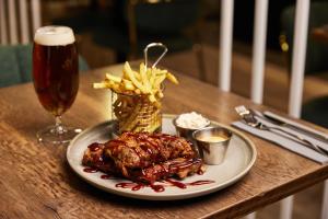 a plate of chicken and french fries and a glass of beer at Konvin Hotel by Reykjavik Keflavik Airport in Keflavík