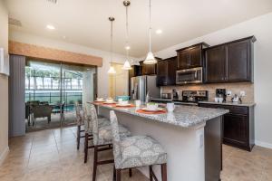 a kitchen with a large island with bar chairs at Large Villa wPrivate Pool Game Room Waterpark in Kissimmee