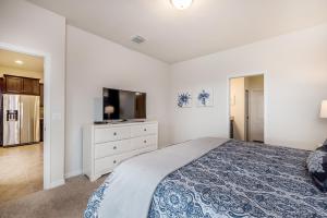 um quarto com uma cama e uma televisão de ecrã plano em Large Villa wPrivate Pool Game Room Waterpark em Kissimmee