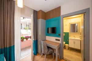 Habitación pequeña con escritorio y TV. en Lynda Hotel en Estambul