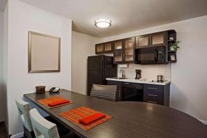 a kitchen with a table with chairs and a kitchen with a kitchen gmaxwell gmaxwell gmaxwell at MainStay Suites- Kansas City Overland Park in Overland Park