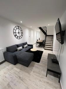 sala de estar con sofá y mesa en Appartement haut de gamme avec Jacuzzi Champagnole en Champagnole